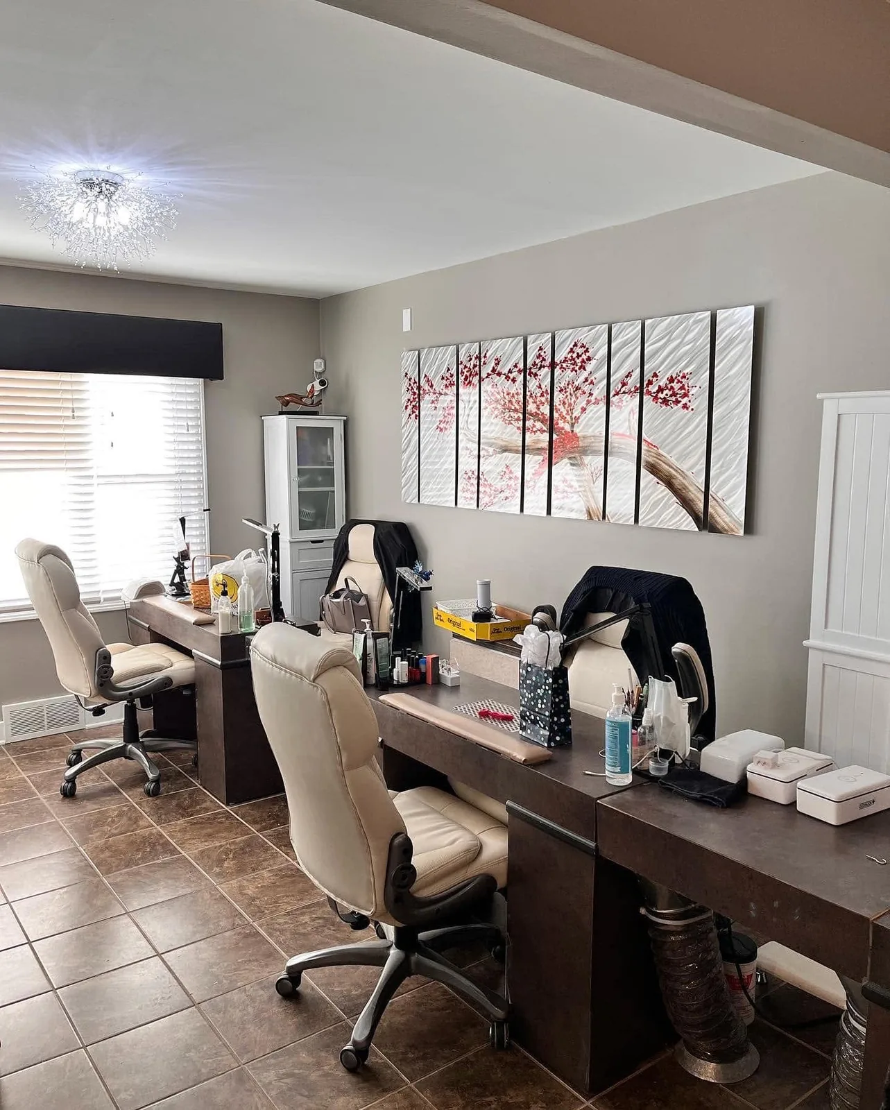 Manicure desks with cream chairs along a wall of paintings
